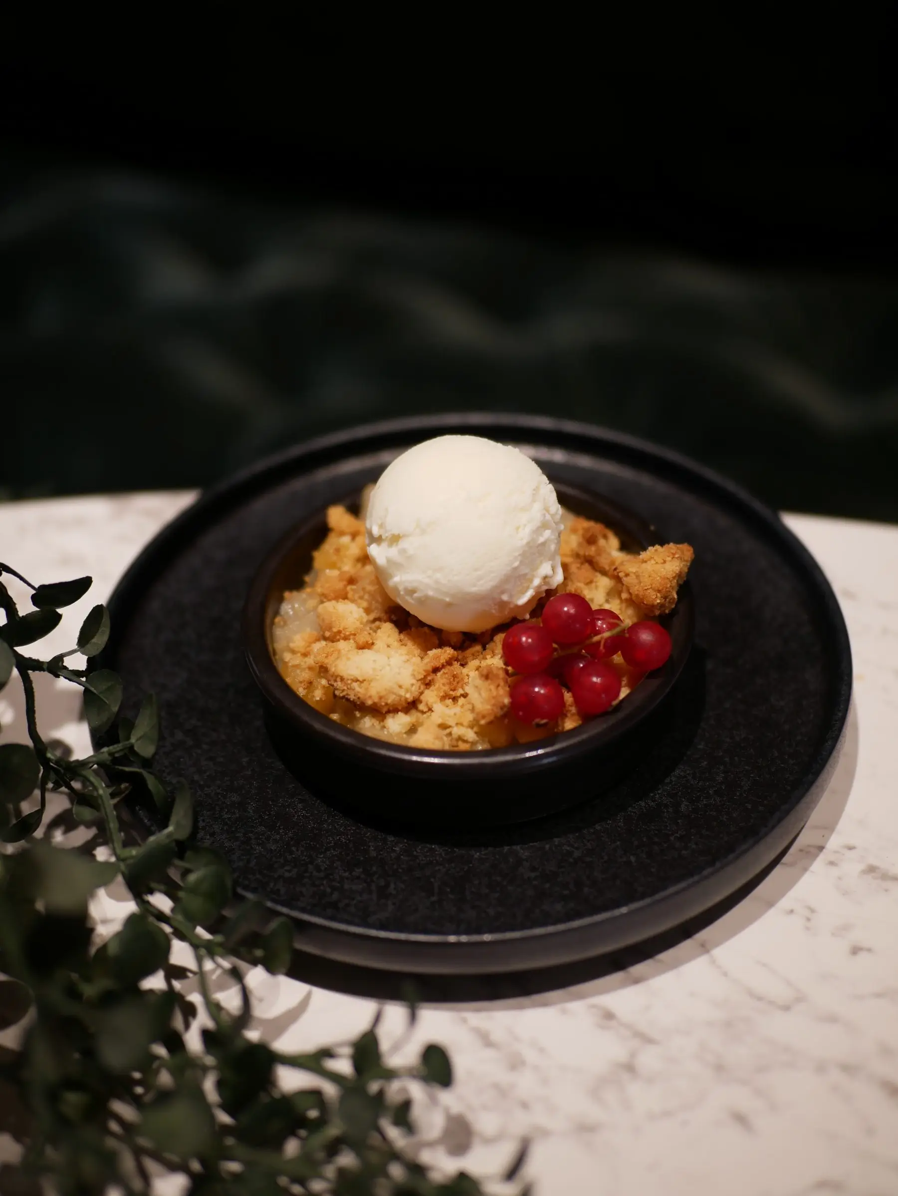 Dessert du Café Gourmand : crumble servi avec une glace et des groseilles.
